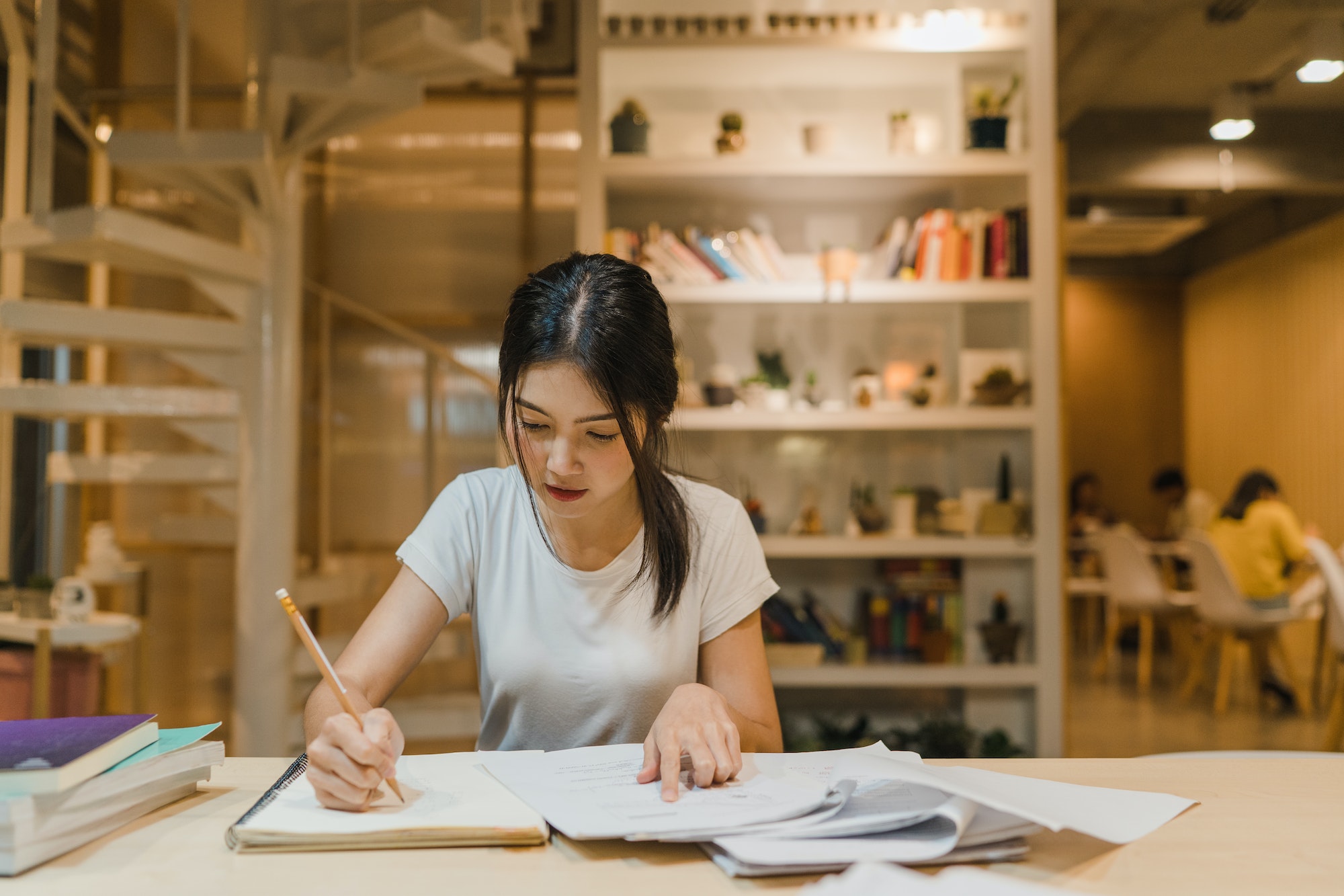 Asian student women reading books in library at university.